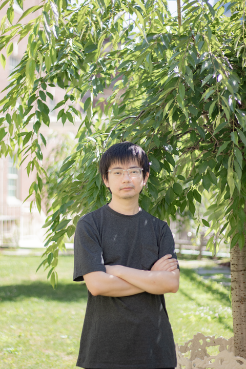 headshot of maohan su, asian man with short black hair and glasses in dark gray t shirt with arms crossed looking at camera